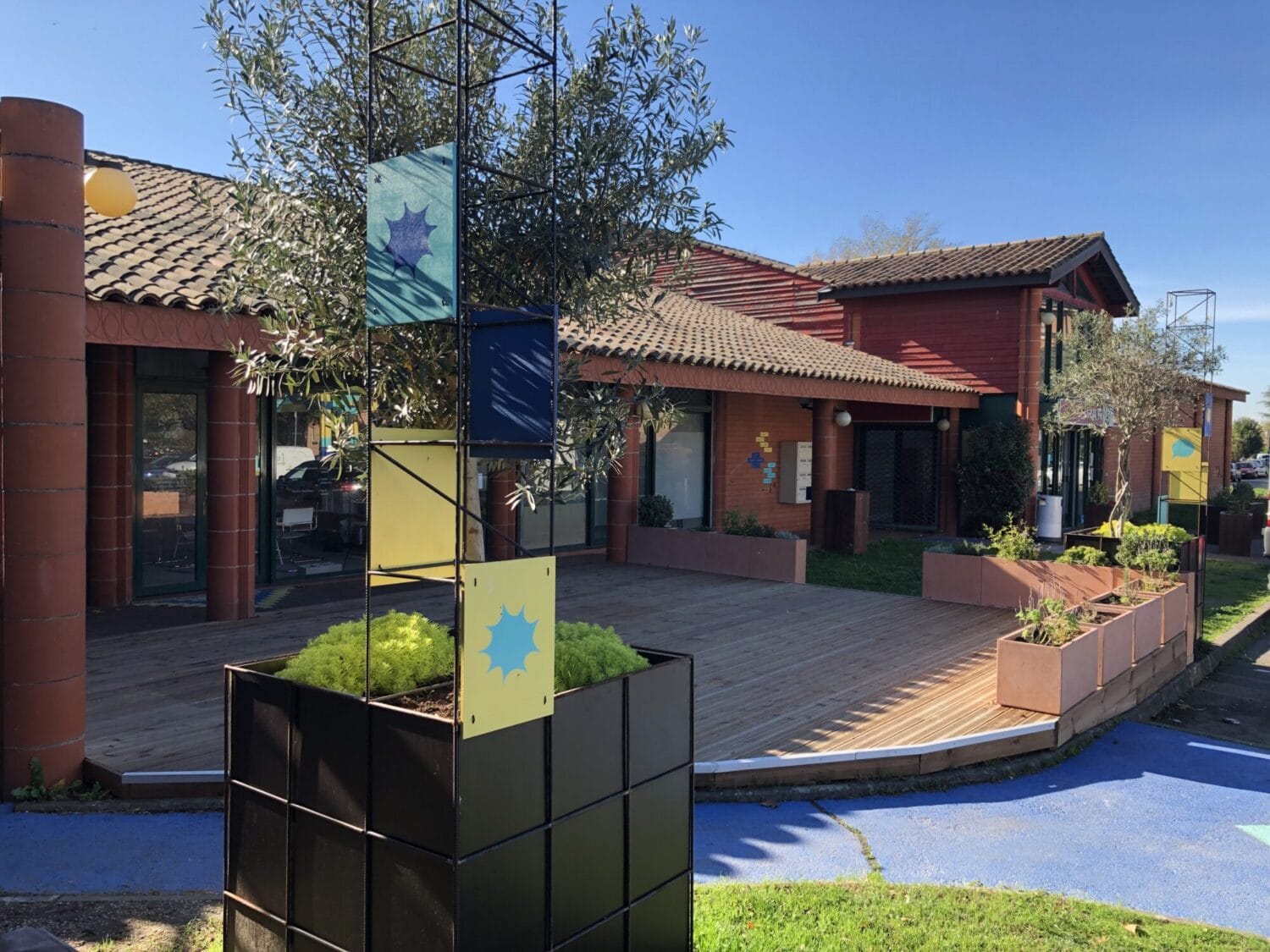 Le Clos Jacquin à Toulouse - crédit Clara Choulet - terrasse d'un centre commercial de proximité avec jardinières, plantes et signalétique colorée