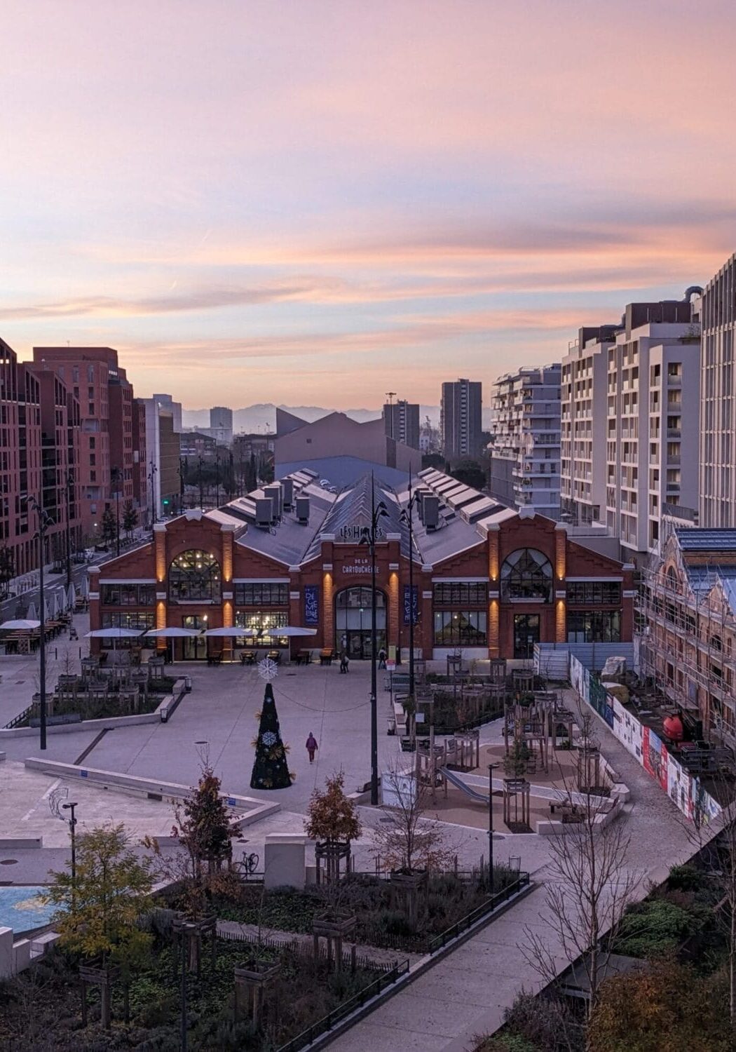 Les Halles de la Cartoucherie à Toulouse, vue au coucher du soleil sur le parvis et le bâtiment