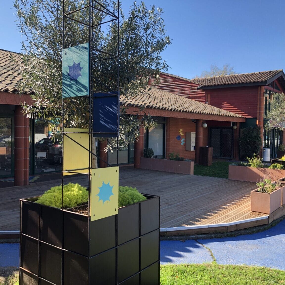 Le Clos Jacquin à Toulouse - crédit Clara Choulet - terrasse d'un centre commercial de proximité avec jardinières, plantes et signalétique colorée